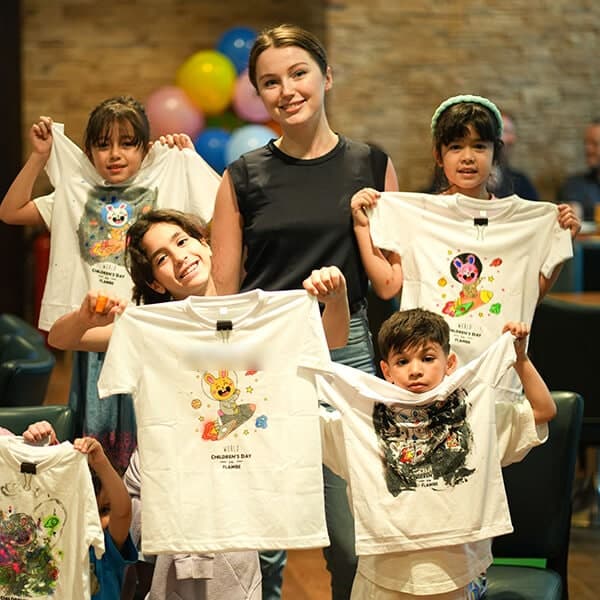 Children holding the T-shirts they painted at a World Children's Day event in Dubai