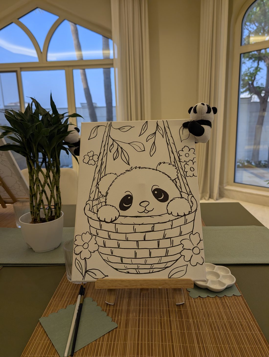 Canvas with a pre-drawn panda in a basket on a tabletop easel, ready to paint at a children's birthday party in Dubai