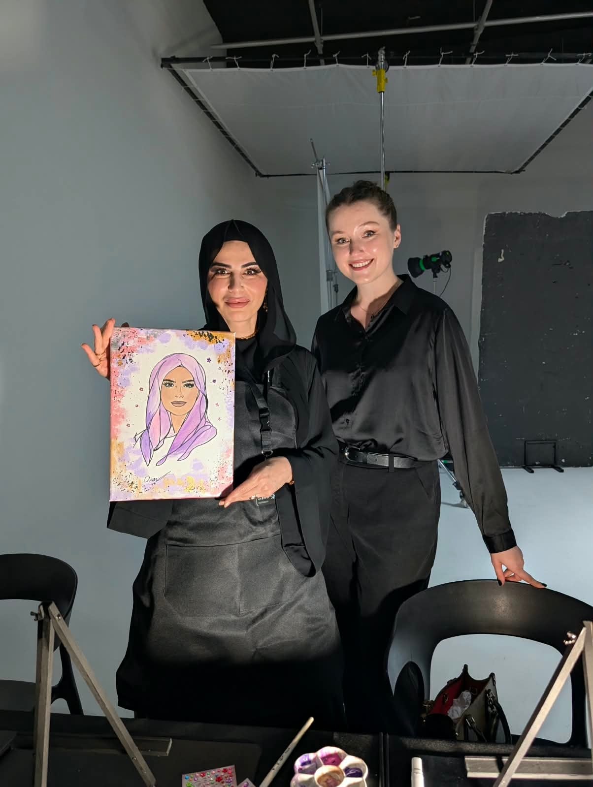 MAC Cosmetics guest holding the self portrait she painted at a Dolce Arty brand activation in Dubai